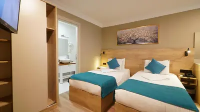 a hotel room with two beds and a bathroom at The Marist Hotel Kadikoy in Istanbul
