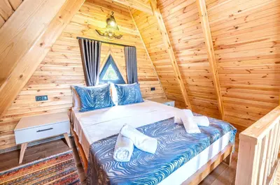 a bedroom with a bed in a log cabin at Aronia Bungalow in Elmalık