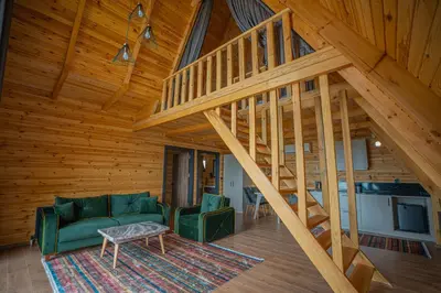 a living room with a staircase in a wooden house at Aronia Bungalow in Elmalık