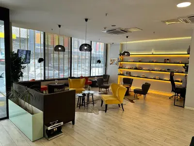 a waiting room with yellow chairs and tables at Tempo Fair Suites in Istanbul