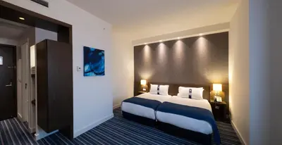 a hotel room with a large bed with blue sheets at FEZ INN Hotel in Istanbul