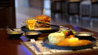 a table with two plates of food with a sandwich and chips at FEZ INN Hotel in Istanbul