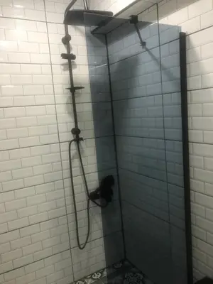 a shower in a bathroom with white tiles at Hotel Hoyuk in Istanbul