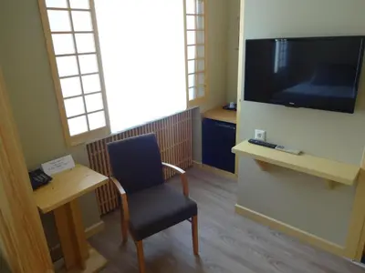 a waiting room with a chair and a flat screen tv at Bunkahaus in Istanbul