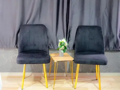 two black chairs and a table with a vase of flowers at Family apartment in Istanbul