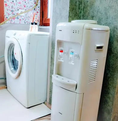 a washer and a washing machine next to a wall at Family apartment in Istanbul