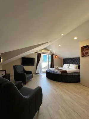 a bedroom with a large bed and two chairs at Monezza Maltepe Rezidans in Istanbul