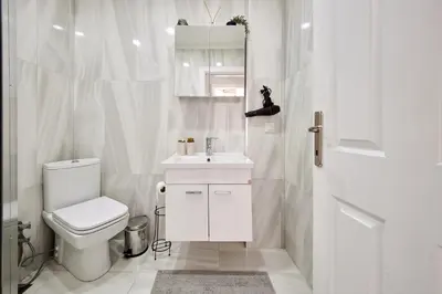 a white bathroom with a toilet and a sink at Cozy Oasis in Moda Steps to Seafront in Istanbul