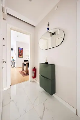 a living room with a green cabinet and a mirror at Cozy Oasis in Moda Steps to Seafront in Istanbul