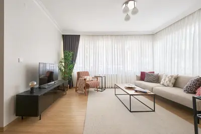 a living room with a couch and a tv at Cozy Oasis in Moda Steps to Seafront in Istanbul