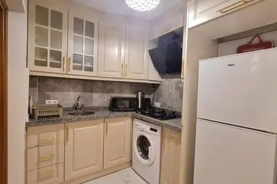 a kitchen with a white refrigerator and a dishwasher at Cozy 2 bedroom near Green Mosque in Yıldırım