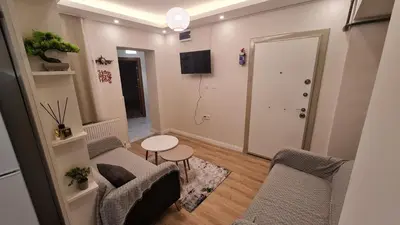 a living room with two chairs and a table at Cozy 2 bedroom near Green Mosque in Yıldırım