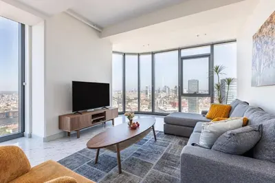 a living room with a couch and a tv at Beautiful Bright Deluxe 1BD Condo PoolViews! #311 in Istanbul
