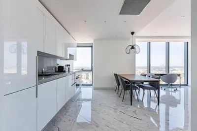 a kitchen with white cabinets and a table with chairs at Beautiful Bright Deluxe 1BD Condo PoolViews! #311 in Istanbul