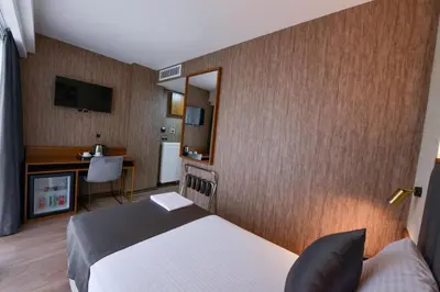 a bedroom with a bed and a desk and a mirror at İSTPORT GARDEN HOTELS in Arnavutköy