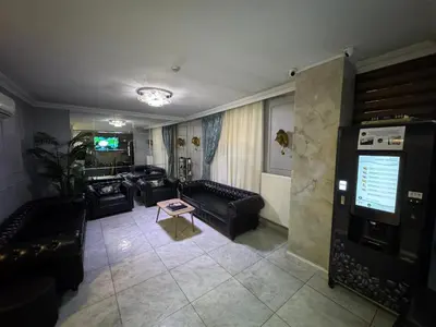 a living room with black couches and a tv at The Canka Residence And Family Apartment Istanbul City Center - ŞIŞLI in Istanbul