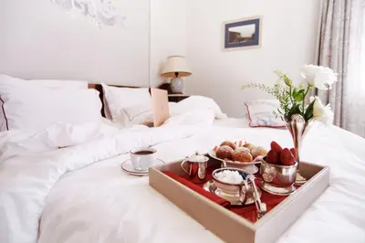 a tray with food and drinks on a bed at Büyükada Splendid Palace Hotel in Buyukada