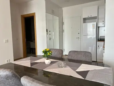 a dining room table with chairs and a vase of flowers at Central Location Free WIFI AC Parking Garage in Esenyurt