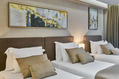 a hotel room with two beds and a painting on the wall at Rayelin Hotel Istanbul Old City in Istanbul