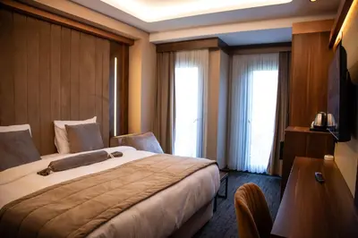 a hotel room with a large bed and two windows at THE PARK HOTEL in Istanbul