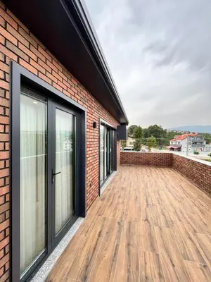 a brick building with a large patio with wooden floors at Serim Residence in Kocaeli