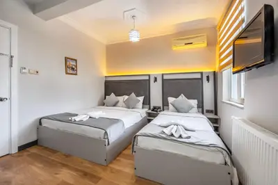 a bedroom with two beds and a flat screen tv at Taksim Trust Hotel in Istanbul