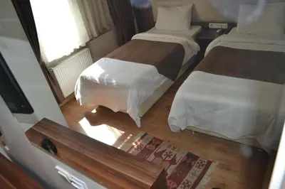 a small bedroom with two beds and a window at New Fatih Hotel in Istanbul