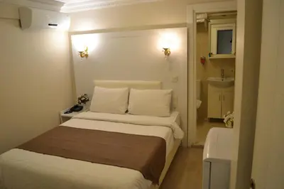 a small bedroom with a bed and a bathroom at New Fatih Hotel in Istanbul