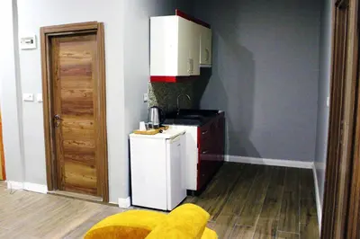 a kitchen with a white refrigerator and a stove at Avist Hotel Avcılar in Avcılar