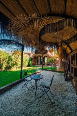a patio with a table and chairs under a roof at Feronia Suites in Masukiye
