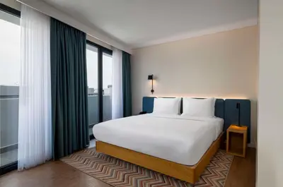 a bedroom with a white bed and a large window at Hampton By Hilton Istanbul Sirkeci in Istanbul