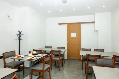 a dining room with tables and chairs and a white wall at mayza otel in Istanbul