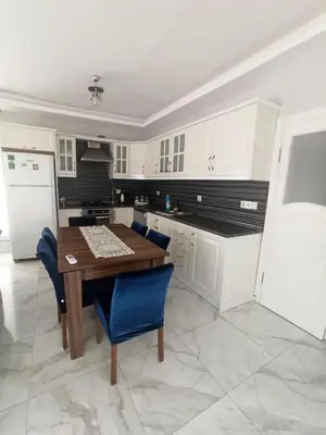 a kitchen with a wooden table and blue chairs at Grandvadi Villa kapalı ısıtmalı havuz in Sapanca