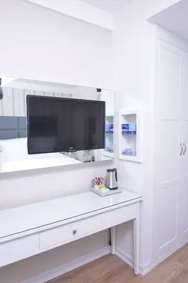 a tv on a white wall in a living room at Ten Rooms Istanbul Hotel in Istanbul