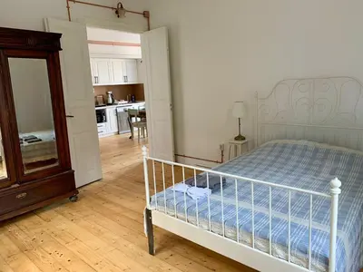 a bedroom with a bed with a mirror and a kitchen at Büyükada Al Köşk in Buyukada
