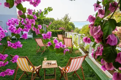 a group of chairs and a table with pink flowers at Mansion Miliá in Adalar