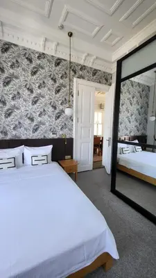 a bedroom with a large white bed and a mirror at Mansion Miliá in Adalar