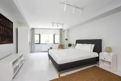 a white bedroom with a large bed and a couch at Gorgeous Bright New 2BD Central Home! #212 in Istanbul