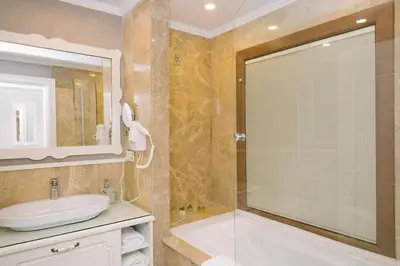 a bathroom with a tub and a sink and a mirror at Burgaz İzer Hotel in Lüleburgaz