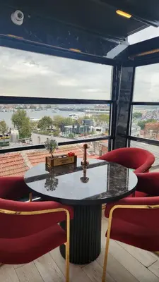 a table and chairs in a room with a large window at Lale Sultan Hotel in Istanbul