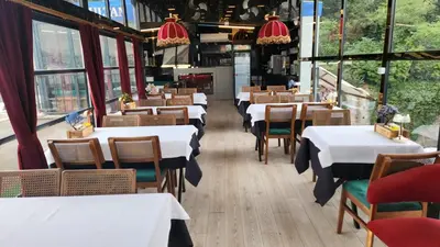 a restaurant with white tables and chairs and windows at Lale Sultan Hotel in Istanbul