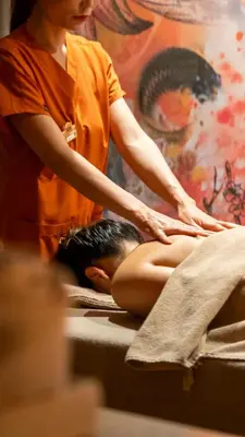 a woman sitting on a bed getting a massage at Nex Hotel & Spa Istanbul in Istanbul