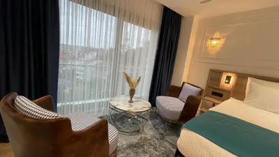a hotel room with a bed and chairs and a window at Mona Bosphorus Hotel in Istanbul