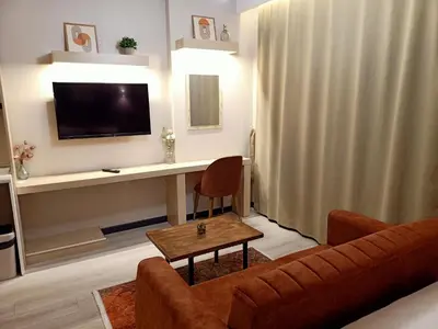 a living room with a couch and a desk with a television at NEW FALCON PALAS OTEL in Istanbul