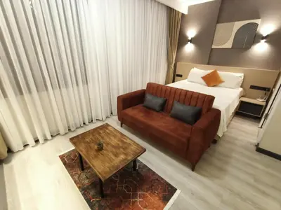 a hotel room with a bed and a couch and a table at NEW FALCON PALAS OTEL in Istanbul