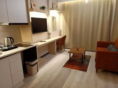 a kitchen and living room with a desk and a couch at NEW FALCON PALAS OTEL in Istanbul