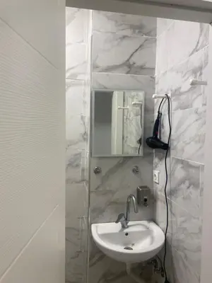 a white bathroom with a sink and a mirror at HOTEL YEDİkapı in Istanbul