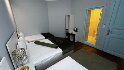 a small room with two beds and a door to a bathroom at Bali Star City Hotel in Istanbul