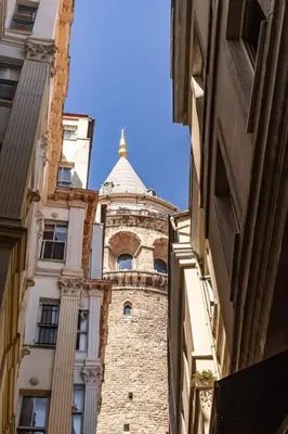 a building with a tower in the middle of two buildings at Warm Rustic Charming 2BD Galata wPatio Gem! #320 in Istanbul