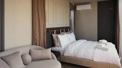 a bedroom with a bed and a couch and a chair at Velour Hotel Spa Restaurant in Sakarya